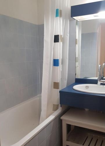 une salle de bain avec un lavabo, une baignoire et un miroir dans l'établissement Appartement au départ des remontées mécaniques - Briançon, à Briançon
