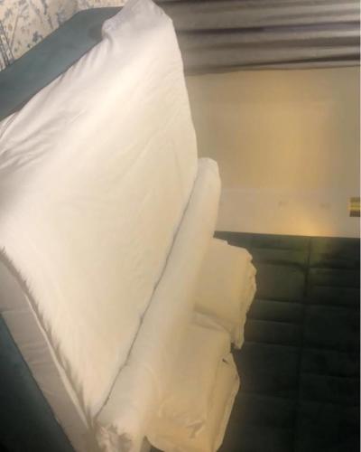 a stack of white sheets on a bed at Lilly court estate area 11 apartment in Abuja