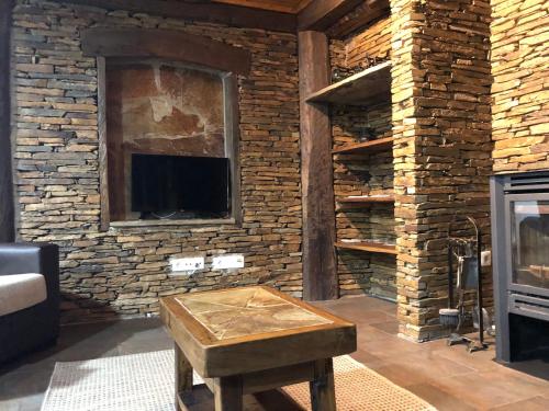 a living room with a brick wall with a fireplace at Casa de Xisto Santo António in Videmonte