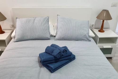 uma cama com duas toalhas azuis em cima em Ocean View Apartment Poris em Poris de Abona
