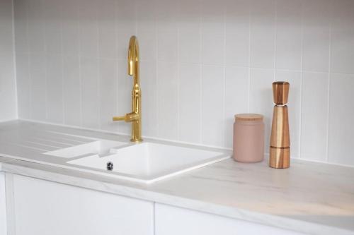 a white sink with a gold faucet on a counter at Massive 2 Bed flat+16 ft high ceiling+NR CURVE in Leicester