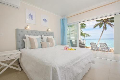 um quarto com uma cama e vista para o oceano em Vaima Beachfront Apartments em Rarotonga