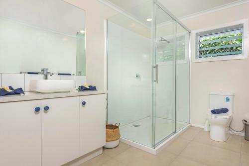 a bathroom with a glass shower and a toilet at Vaima Beachfront Apartments in Rarotonga