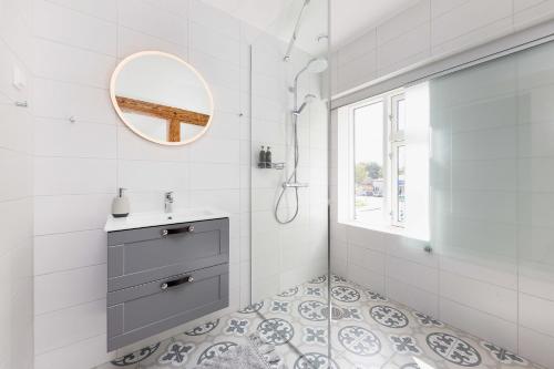 a white bathroom with a sink and a mirror at Kipperi Kodumajutus in Lihula