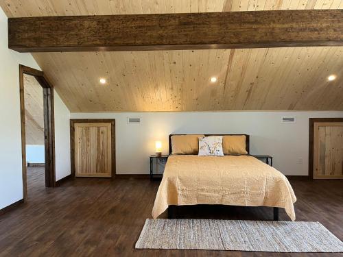 um quarto com uma cama e um tecto de madeira em Le Bōrivage em Audet