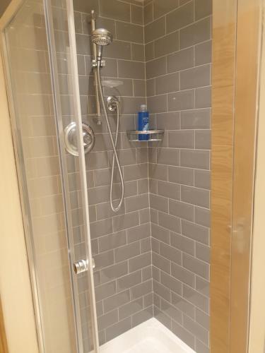 a shower stall with a shower head in a bathroom at London Luxury 3 bedroom 2 bathrooms flat 1 min to Redbridge Station FREE parking & WIFI in Wanstead