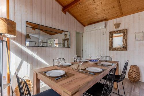 une salle à manger avec une table et des chaises en bois dans l'établissement Capfun 5 stars 64 m with pool and terrace, à Lanton
