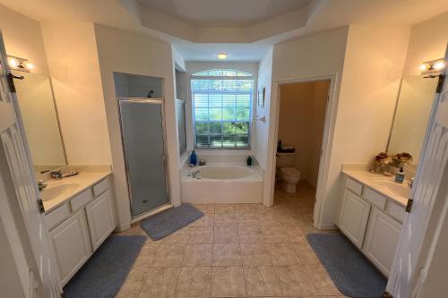 y baño con bañera, ducha y lavamanos. en Destination Beach Stroll en Fort Myers