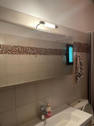 łazienka z umywalką, lustrem i toaletą w obiekcie Stymfalia Cozy Village Guesthouse w mieście Kartérion