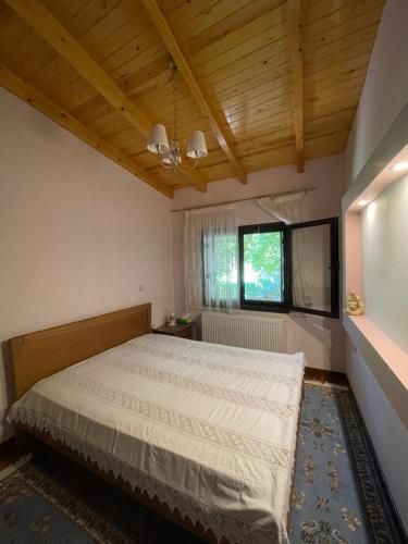 Stymfalia Cozy Village Guesthouse في Kartérion: غرفة نوم بسرير ونافذة