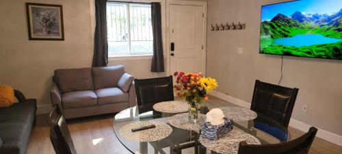 a living room with a table and chairs and a television at Oscar INN & 2bd Family Suite or Private Room in Abbotsford