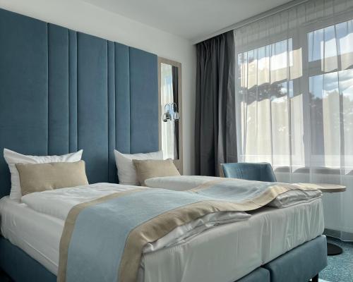 a bedroom with a large bed and a window at Hotel Leuchtturm in Timmendorfer Strand