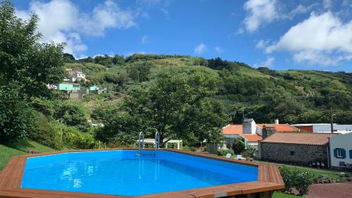 a swimming pool with a mountain in the background at Casa do Açor - Villaverde Azores in Feteiras