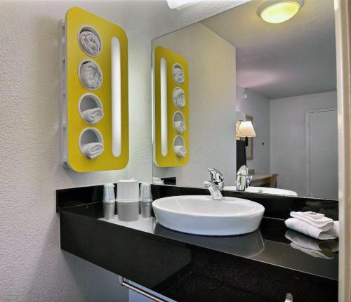 uma casa de banho com um lavatório branco e um espelho. em Motel 6-Bismarck, ND em Bismarck