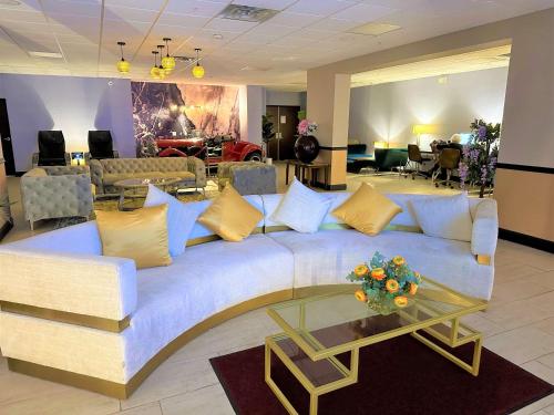 a living room with a large couch with yellow pillows at Albany Airport Inn in Albany
