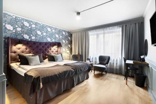 a bedroom with a large bed and a desk at Best Western Princess Hotel in Norrköping