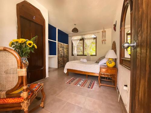 a bedroom with a bed and a vase of flowers at Hotel Gilda in Coyuca