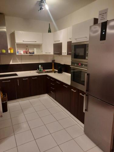 a kitchen with wooden cabinets and a stainless steel refrigerator at Apartmán Zuzu FREE Parking in Trenčín