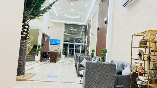 un vestíbulo con sillas y una palmera en Aljadel hotel, en Al Kharj