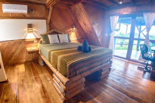 a bedroom with a bed in a log cabin at Vistamar Guest House in Ayampe
