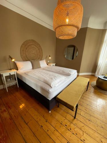 ein Schlafzimmer mit einem großen Bett und einem Kronleuchter in der Unterkunft AUERSTEIN-Hotels auerstein & auerstein-mono in Heidelberg