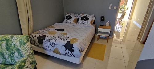 1 dormitorio con cama con edredón y almohadas en T2 Morpho - moderne et chaleureux, en Rémire-Camp