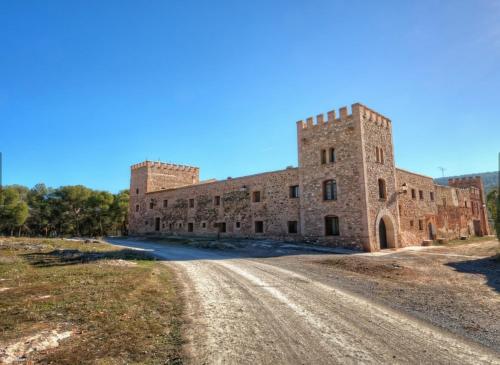 an old brick building on a dirt road at MASÍA de SAN JUAN CASA NÚMERO 1 en Castillo con piscina y Aire Acondicionado in Segorbe