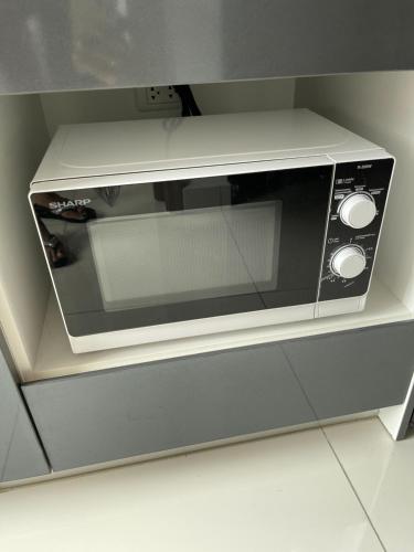 a microwave oven sitting on top of a counter at Brand New 1Bdr Condo! 5 minutes from Famous Walking Street! in Pattaya South