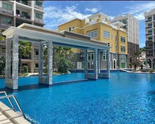 a swimming pool with blue water in front of a building at Brand New 1Bdr Condo! 5 minutes from Famous Walking Street! in Pattaya South