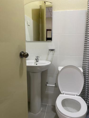 a white bathroom with a toilet and a sink at VBermor Hotel in Santo Domingo