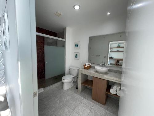 La salle de bains est pourvue d'un lavabo, de toilettes et d'un miroir. dans l'établissement HOTEL TRAMONTO MAZATLAN, à Mazatlán