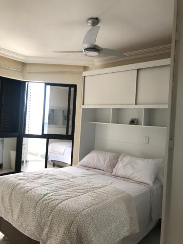 Lindo apartamento com vista para o mar في ماتينيوس: غرفة نوم بسرير ومروحة سقف