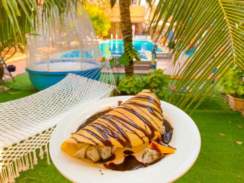 a plate of food on a table next to a pool at MAY Bungalow in Mui Ne