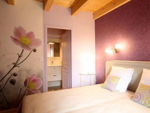 1 dormitorio con 1 cama con una flor en la pared en Gîte Freycenet-la-Cuche, 6 pièces, 14 personnes - FR-1-582-23 en Freycenet-la-Cuche