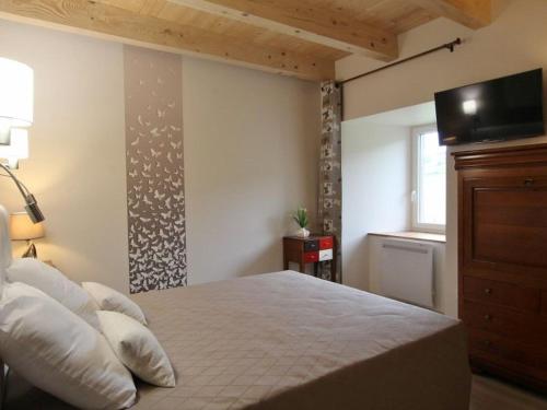 a bedroom with a bed with a television on the wall at Gîte chaleureux 5 chambres près de Freycenet-la-Cuche, idéal pour familles et amis, animaux admis - FR-1-582-23 in Freycenet-la-Cuche
