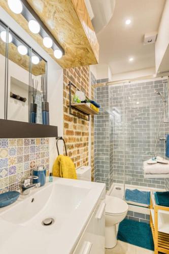 une salle de bain avec un lavabo blanc et des toilettes dans l'établissement Escale à Paris Metro & Parking, à Saint-Ouen