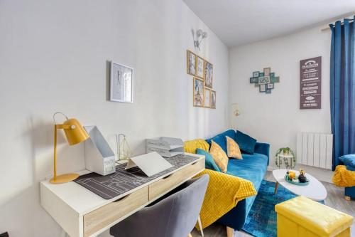 a room with a desk with a laptop and a couch at Escale à Paris Metro & Parking in Saint-Ouen