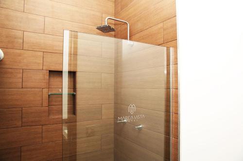 y baño con ducha y puerta de cristal. en Hotel Marea Vista, en Ensenada