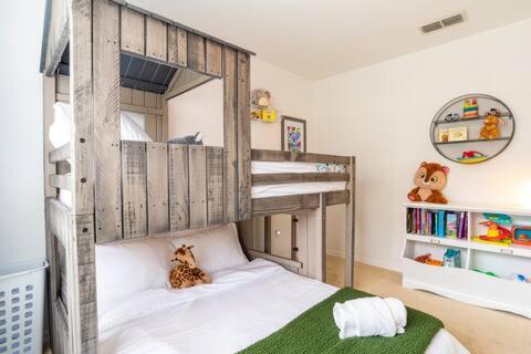 a childs bedroom with a bunk bed with white sheets at The Villas at Seven Dwarfs - Close to Disney in Kissimmee