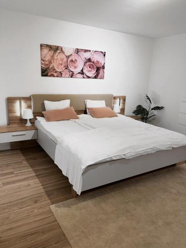 a bedroom with a large white bed with pink roses at Eine schöne Wohnung im Herzen von Basel. in Basel
