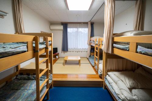 a dorm room with bunk beds and a window at iseshima youth hostel in Shima