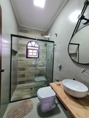 a bathroom with a shower and a toilet and a sink at Cond loft novo à 400 m da praia in São Sebastião