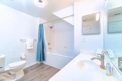 a white bathroom with a toilet and a sink at The Villas at Seven Dwarfs - Close to Disney in Kissimmee