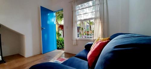 sala de estar con sofá azul y ventana en Happy Sweet Home 3, en São Paulo