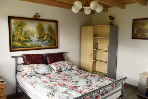 a bedroom with a bed with a painting on the wall at Wczasy u Gospodarza na Kaszubach in Kistowko
