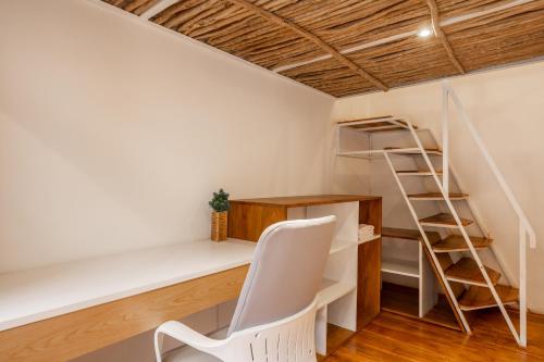 a room with a desk and a ladder and a chair at Clan Living - The Founder Ubud in Ubud