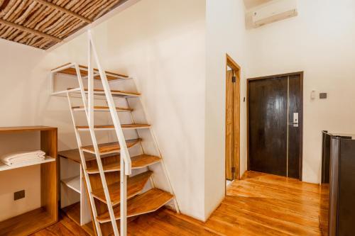Una escalera de caracol en una habitación con puerta en Clan Living - The Founder Ubud en Ubud