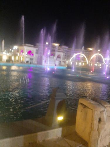 a city at night with a fountain in the water at Chalets in Porto Sharm in Sharm El Sheikh