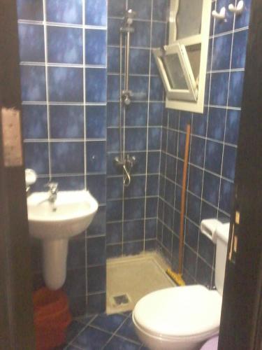 a blue tiled bathroom with a toilet and a sink at Chalets in Porto Sharm in Sharm El Sheikh