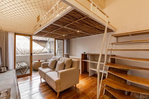 sala de estar con sofá y cama elevada en Clan Living - The Founder Ubud en Ubud